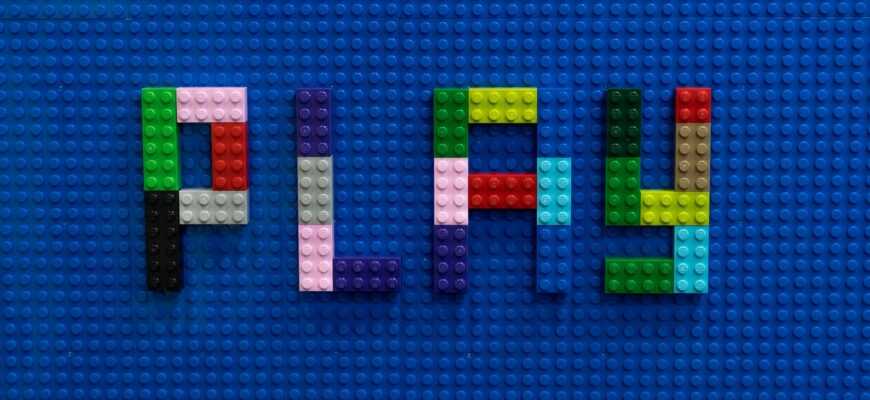 the word play spelled out of legos on a blue surface